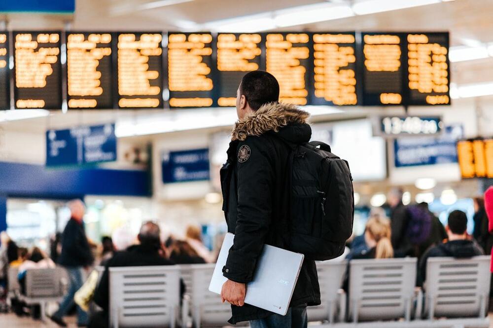 Executivo consultando o painel de voos em um aeroporto