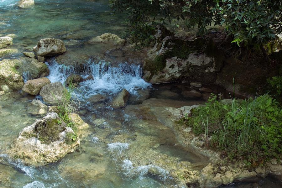 Pequena cachoeira caindo sobre pedras em um rio de água clara