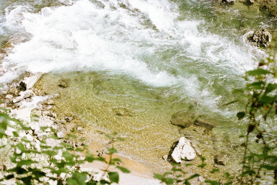 Rio de águas transparentes correndo sobre pedras