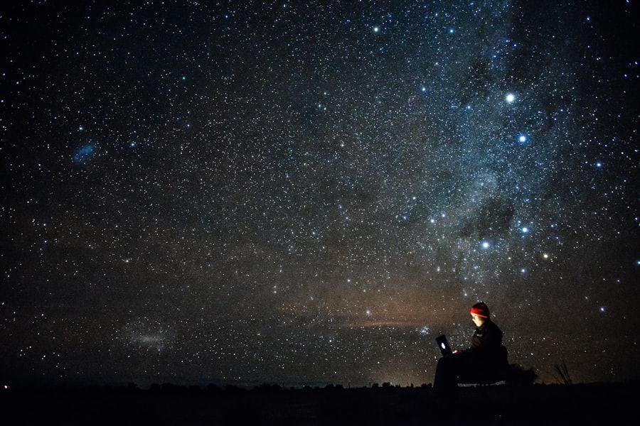 Céu estrelado sobre o deserto, com uma pessoa observando o horizonte